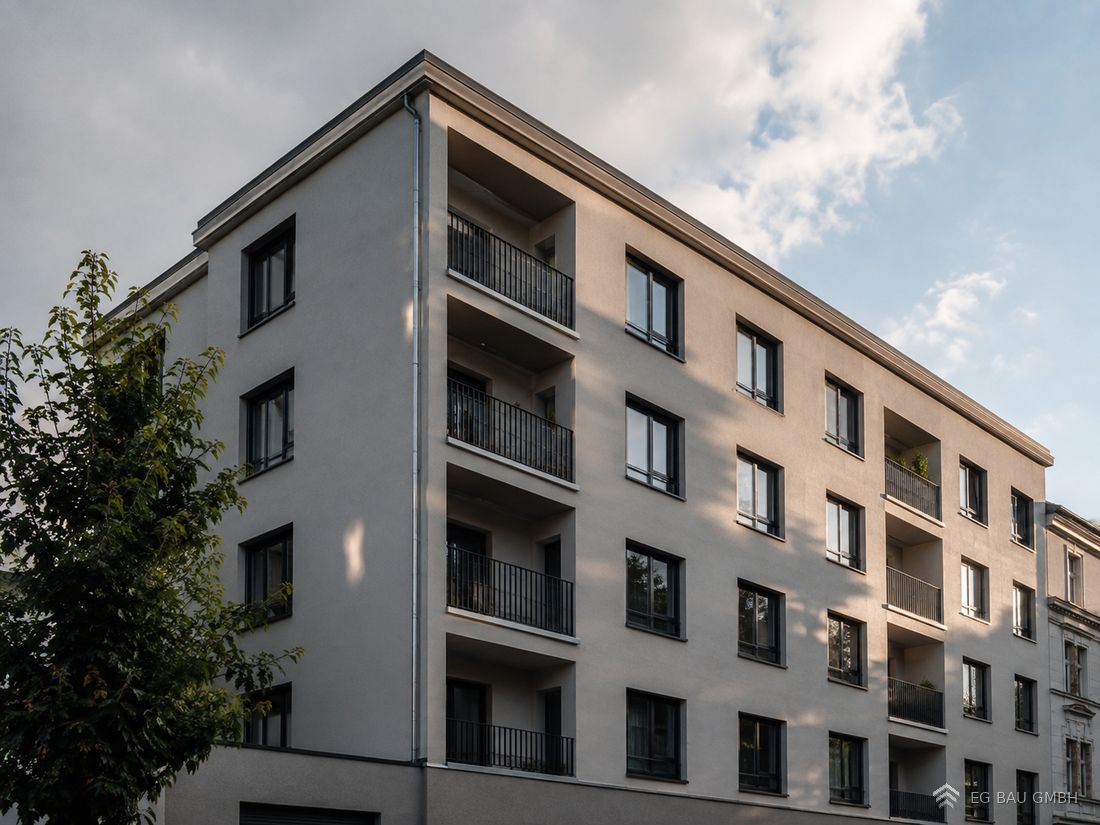 Neu verputzte Fassade eines mehrgeschossigen Wohngebäudes im Abendlicht